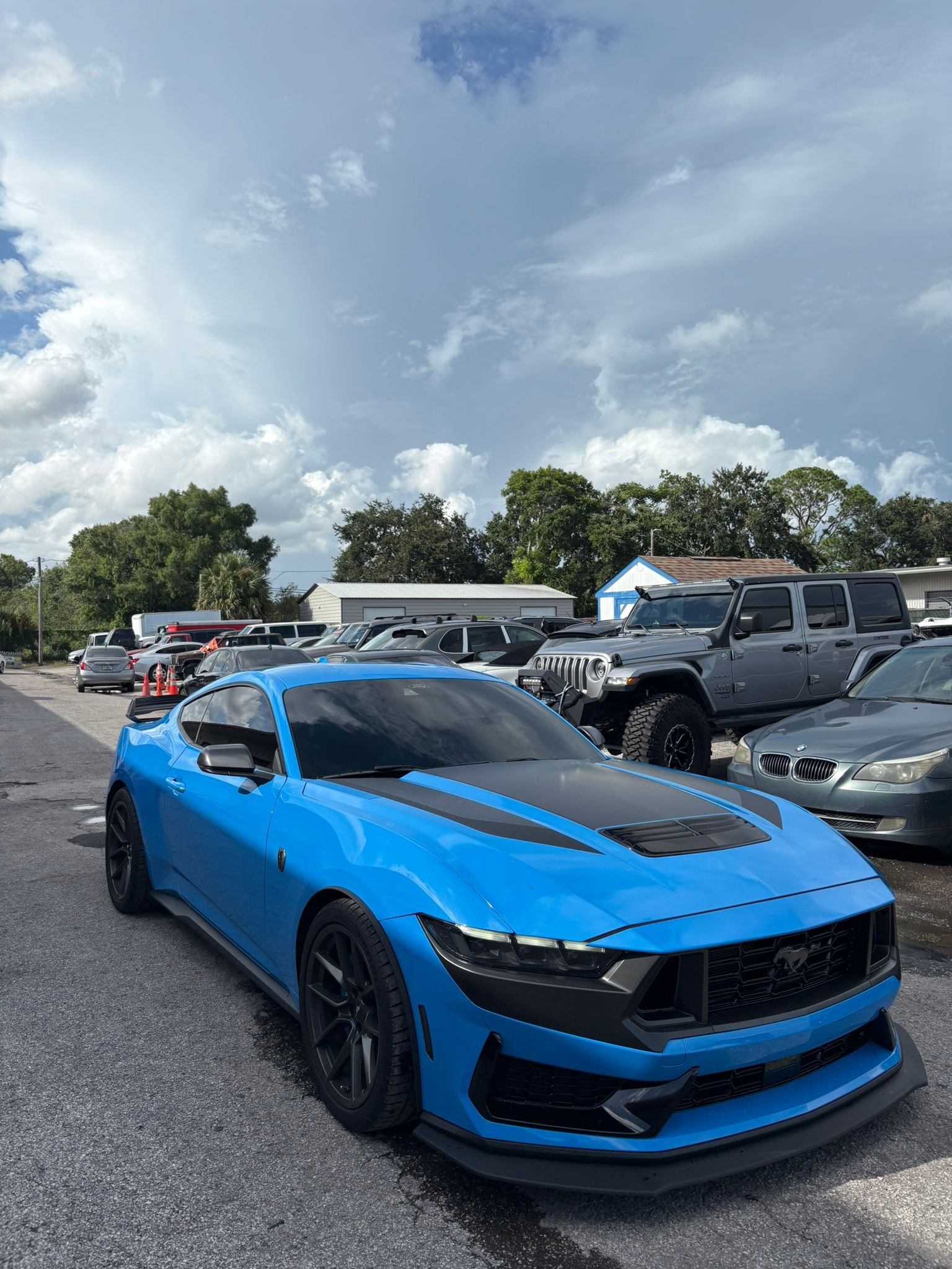 Blue Mustang Dark Horse in parking lot.